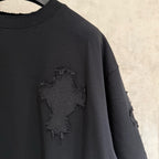 Black short-sleeve T-shirt close-up of chest cross applique with frayed edges