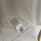 White short-sleeve T-shirt hem with care label and embroidered cross motif
