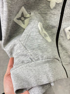 Gray zip-up long-sleeve sweatshirt with star appliques on the chest