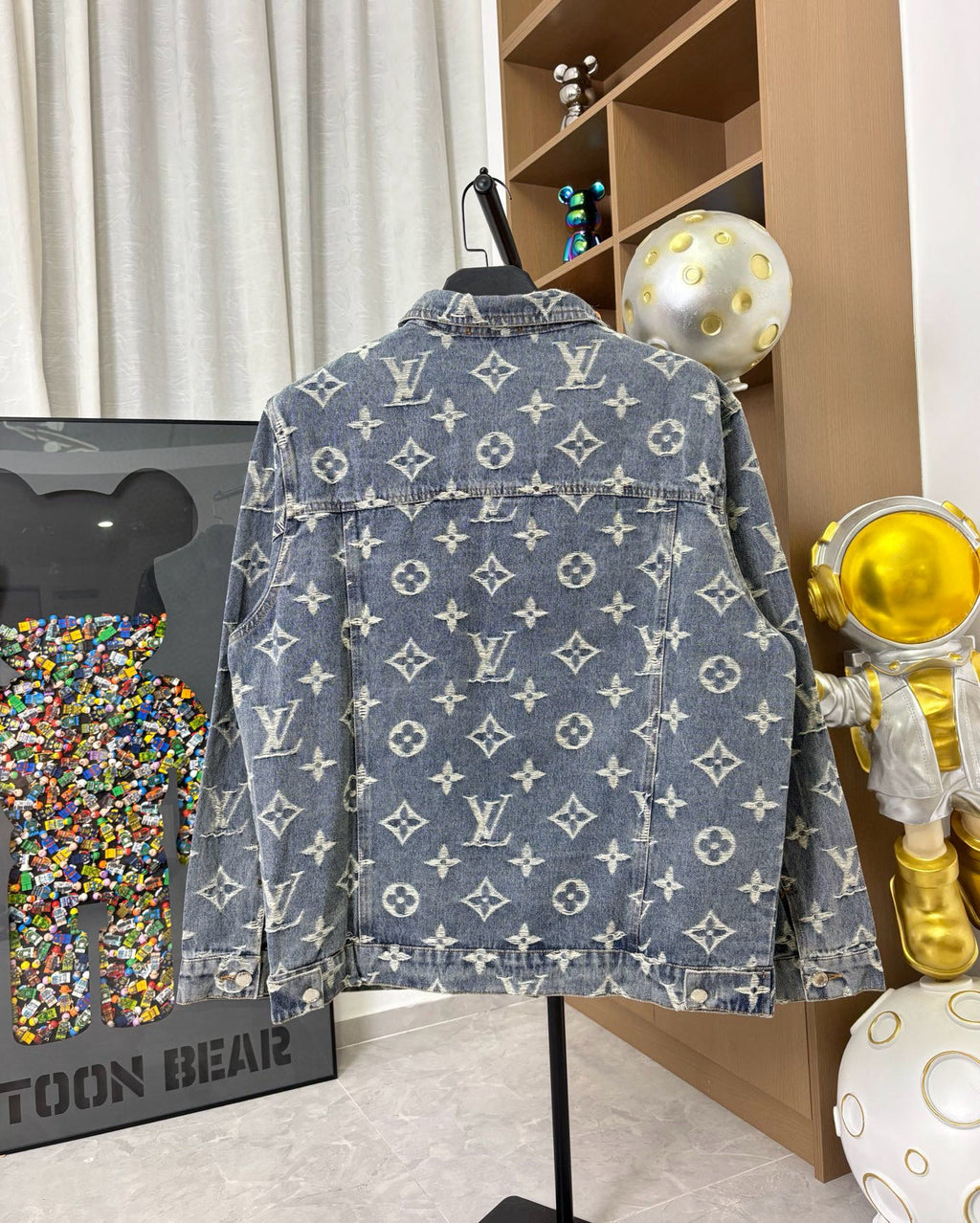 Louis Vuitton denim jacket back view with blue wash and gold monogram pattern, button closure.