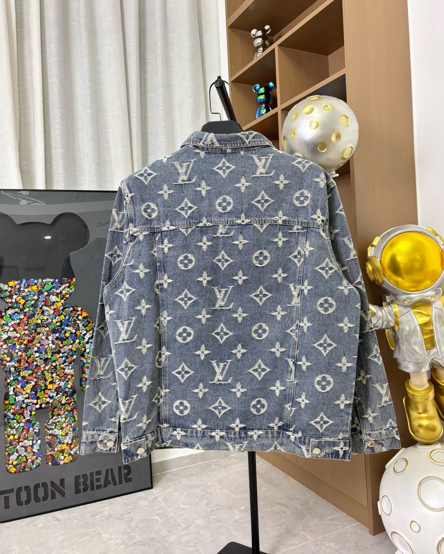 Louis Vuitton denim jacket back view with blue wash and gold monogram pattern, button closure.