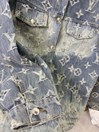 Louis Vuitton denim jacket detail close-up with gold monogram pattern and buttoned flap pockets.