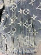 Louis Vuitton denim jacket lower body close-up with gold monogram pattern and button trim.