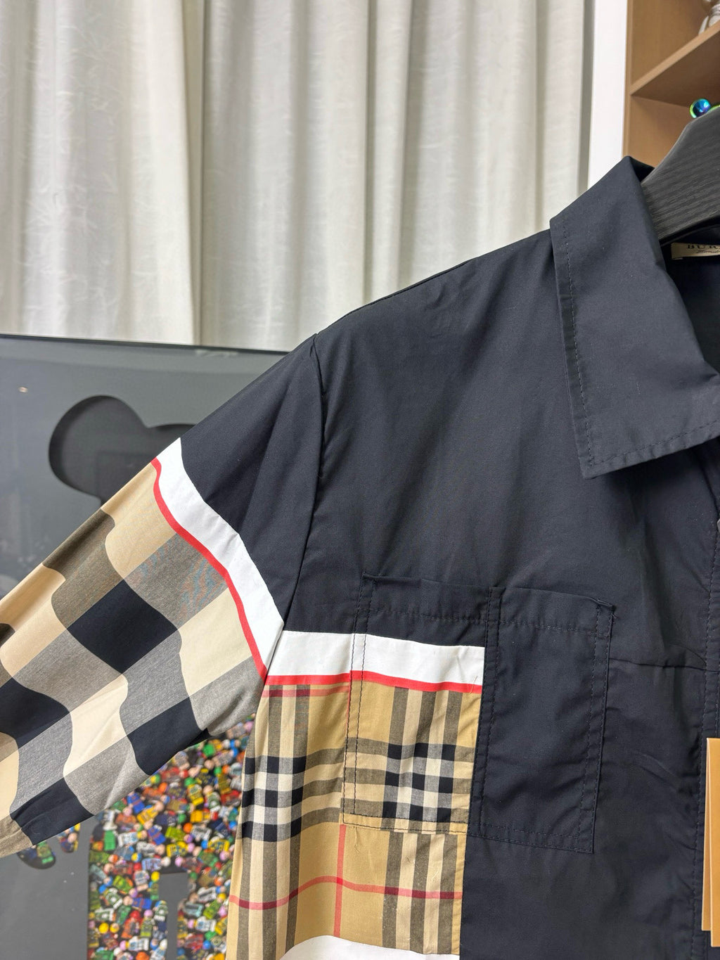 Burberry jacket close-up: navy shoulder with beige plaid stripe panel