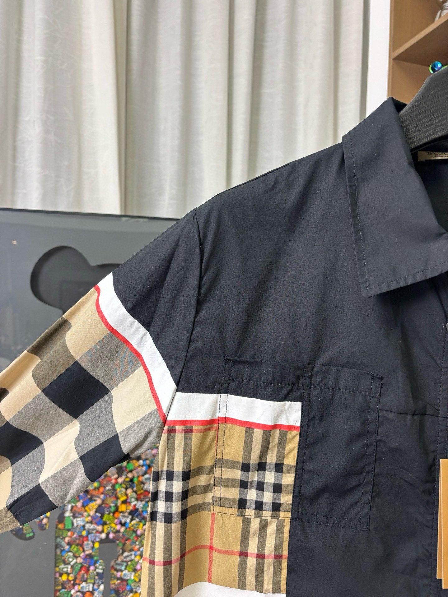 Burberry jacket close-up: navy shoulder with beige plaid stripe panel