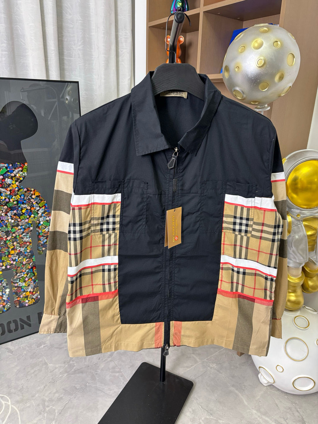 Burberry jacket front view: navy shell with plaid blocks in beige, red, and blue