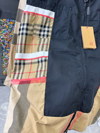 Burberry jacket close-up: navy panel with beige plaid and red stripe hem