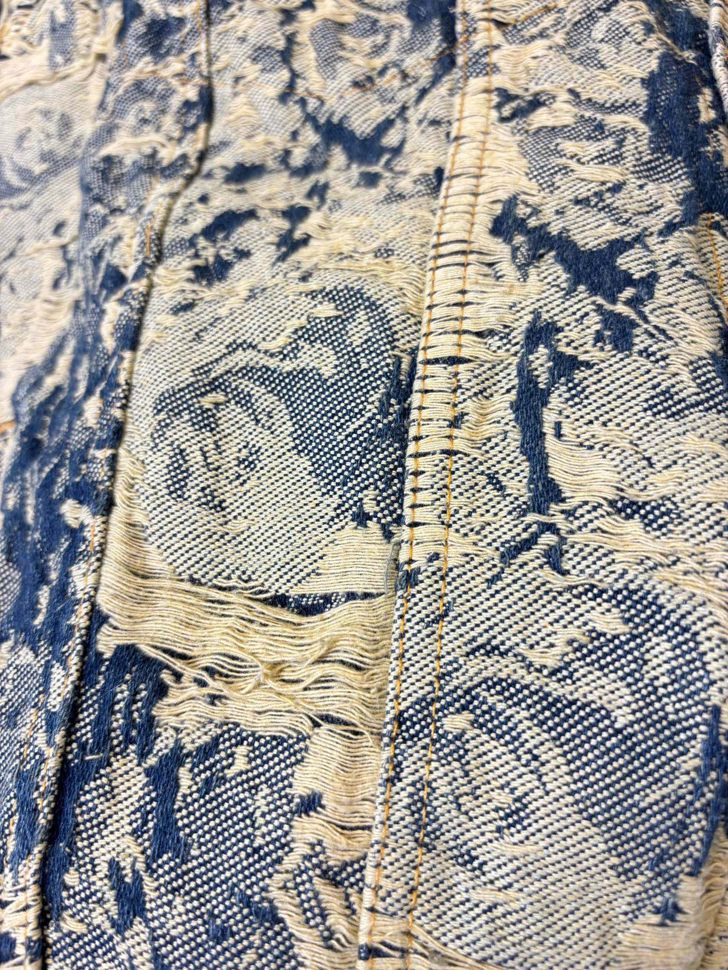 Long-sleeve jacket pocket and button placket detail, blue and cream texture