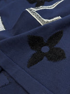 Navy T-shirt with black clover flower appliques and rhinestone lettering detail