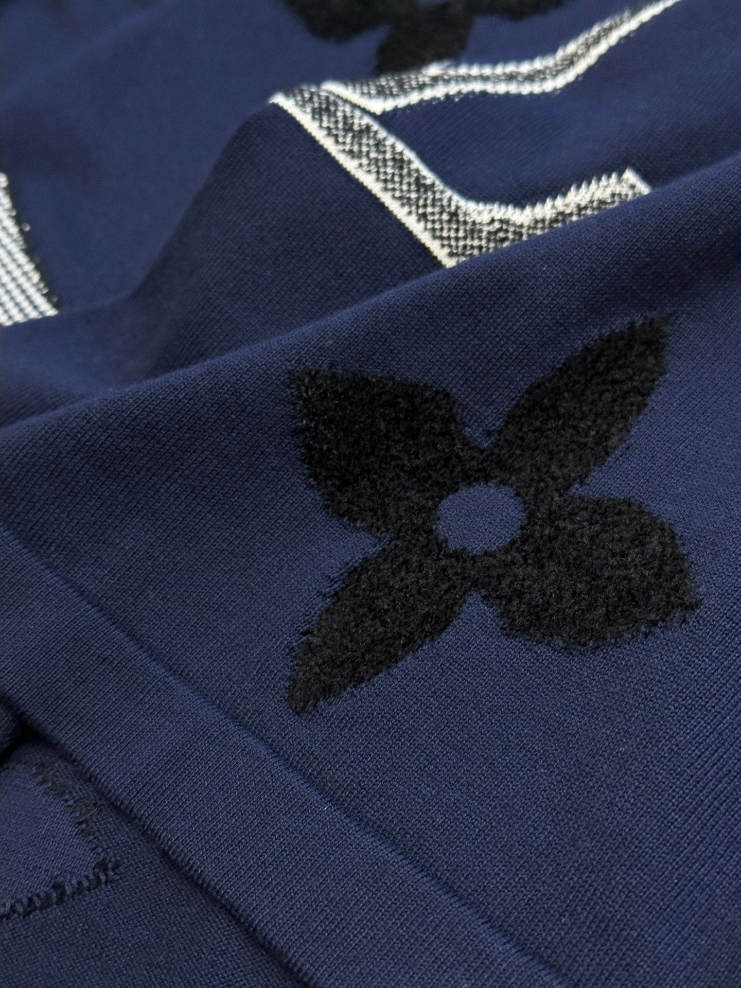 Navy T-shirt with black clover flower appliques and rhinestone lettering detail