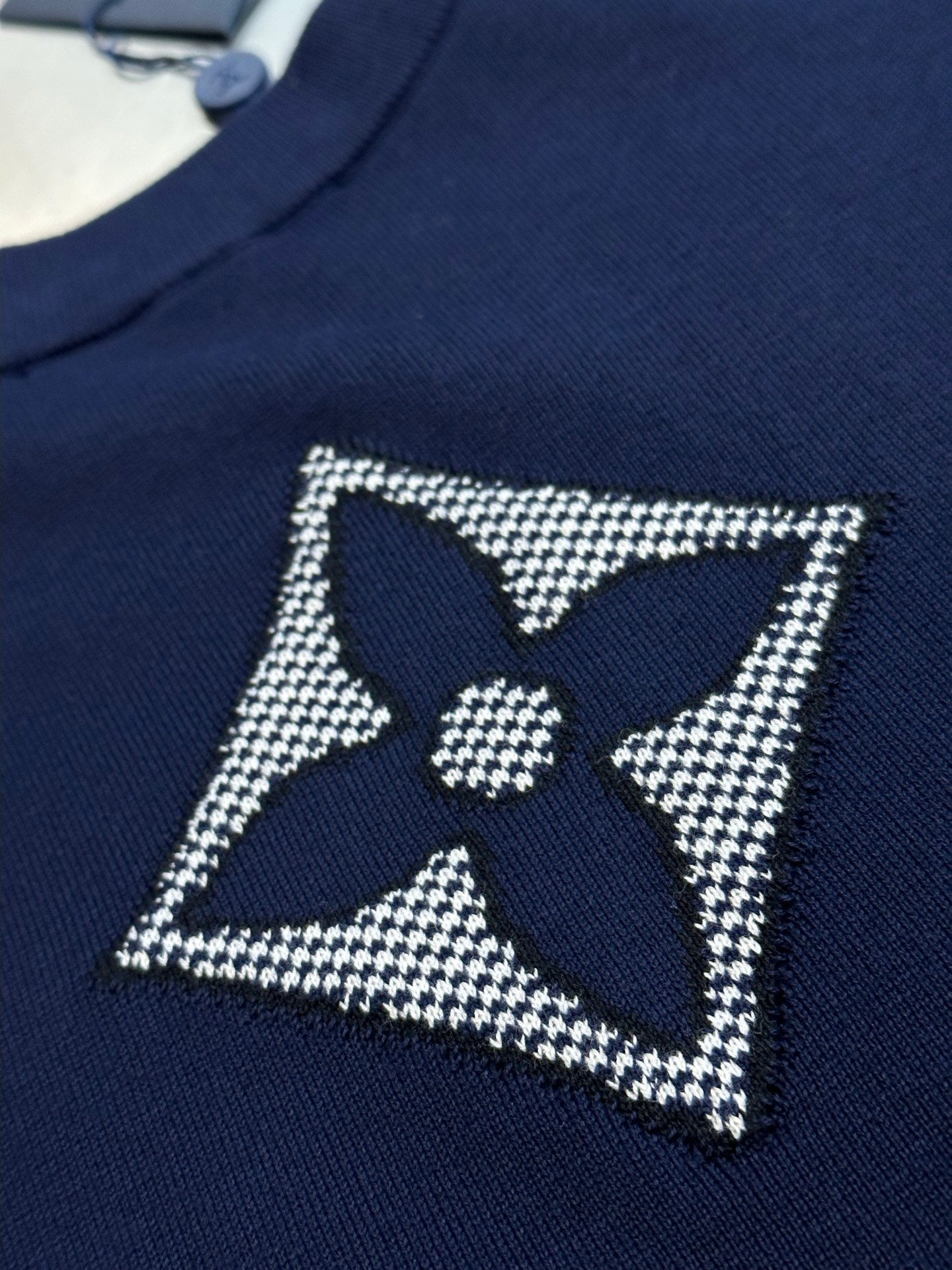 Navy T-shirt with rhinestone star badge and central quatrefoil logo
