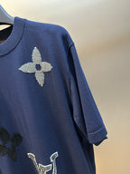 Navy T-shirt sleeve with rhinestone flower and dark clover graphic detail