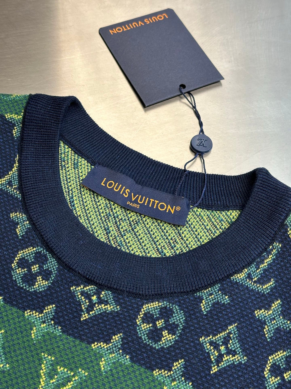 Crew neck collar with navy trim and green monogram knit label