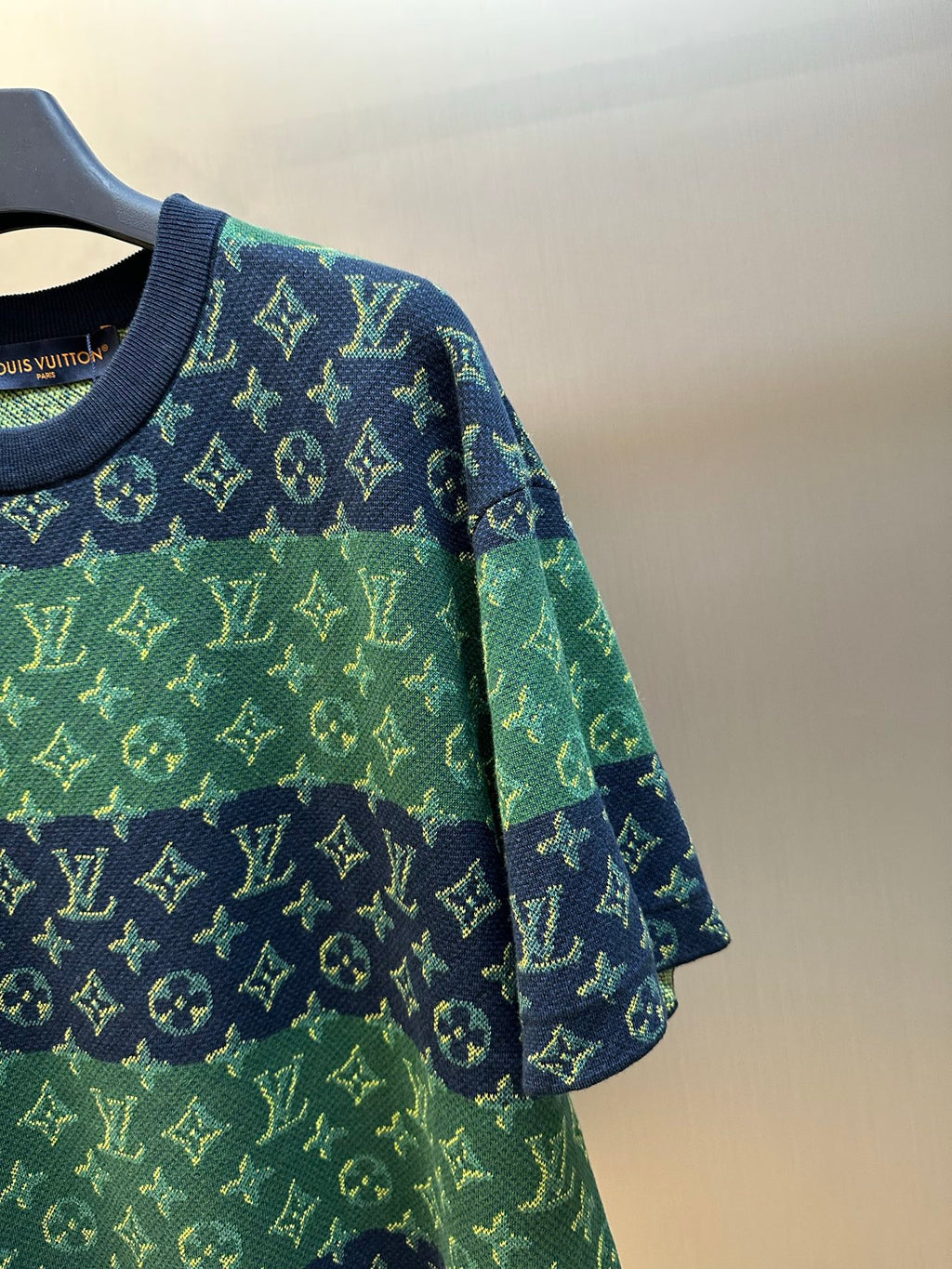 Knit short-sleeve top sleeve detail with navy trim and green monogram pattern