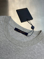 Light gray T-shirt collar with fabric tag and string pull tag near neckline