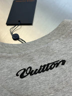 Grey T-shirt neckline with hanging tag and script logo graphic on chest