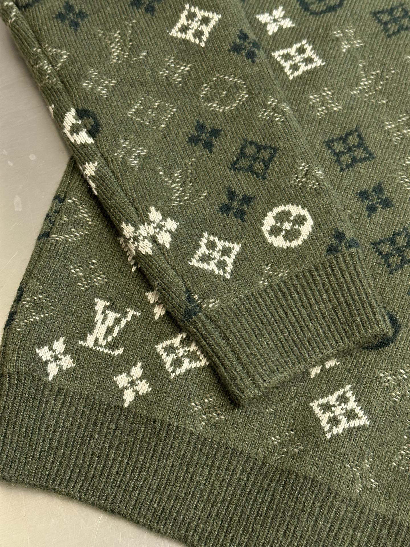 Louis Vuitton knit sweater hem detail in olive green with monogram pattern knit texture