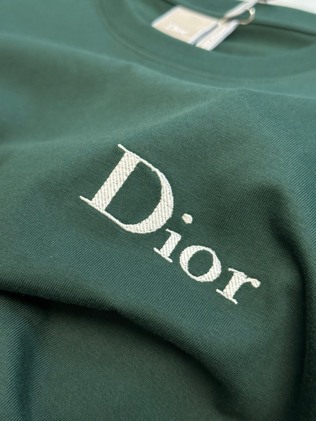 D-shaped Dior logo print on green T-shirt fabric