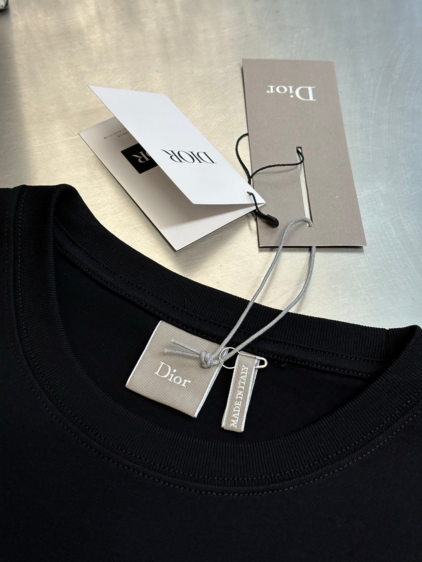 Dior crewneck T-shirt neckline in dark navy with hanging price and care tags
