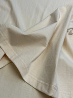 Cream T-shirt draped fabric close-up with stitched sleeve hem