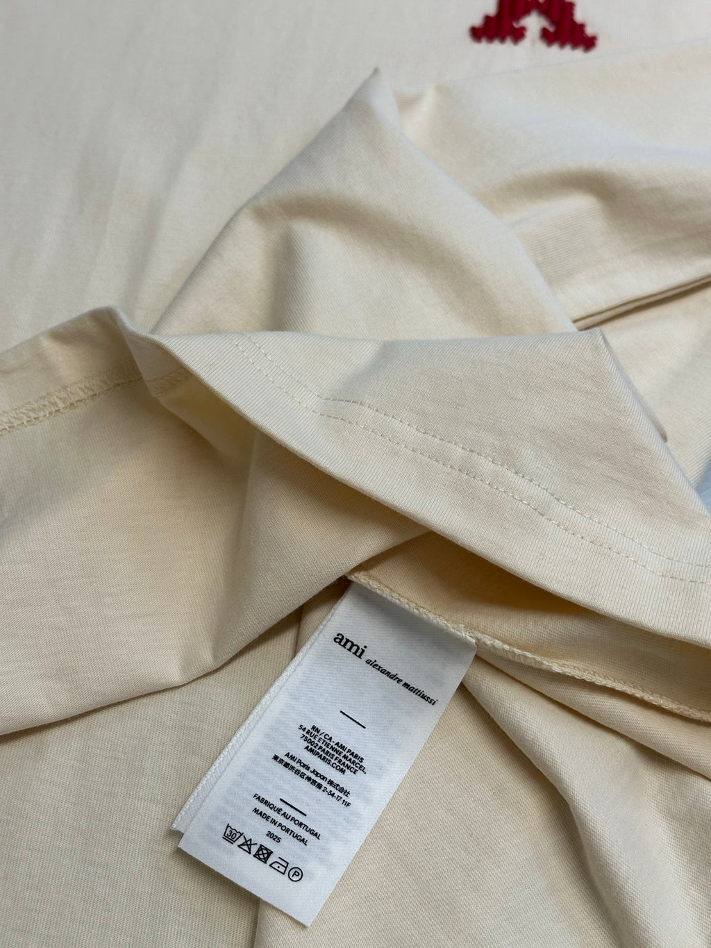 Cream T-shirt fabric fold with white size label tag attached