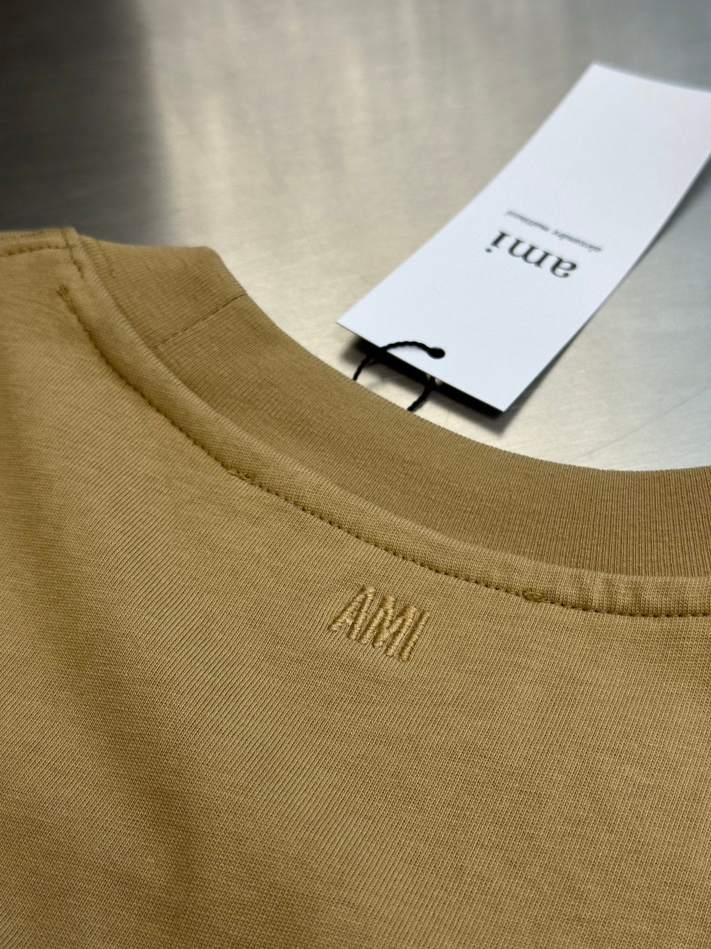 Amiri T-shirt light tan neckline with AM I embroidery and white hang tag