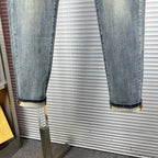 Light blue denim jeans with cuffed hems and subtle fade on knees