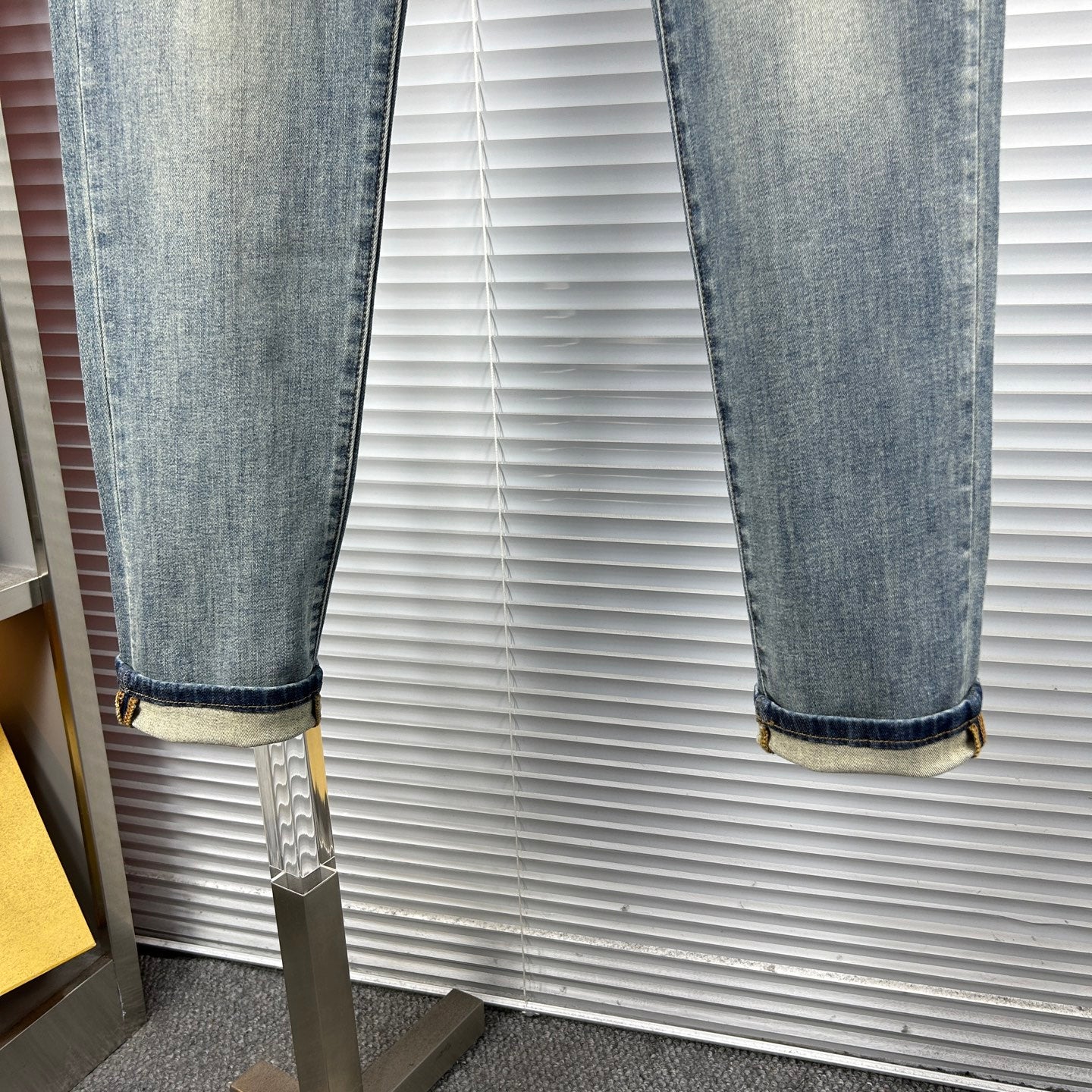 Light blue denim jeans with cuffed hems and subtle fade on knees