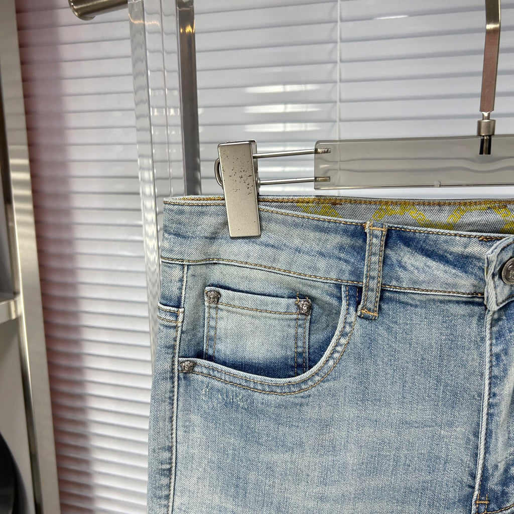 Light blue denim jeans with front coin pocket and stitched waistband label area