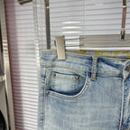 Light blue denim jeans with front coin pocket and stitched waistband label area