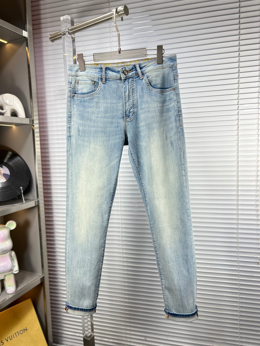 Light blue straight-leg jeans on hanger, cuffed hems and denim belt loops