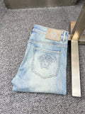 Light blue jeans with topstitched front pockets and Versace logo patch