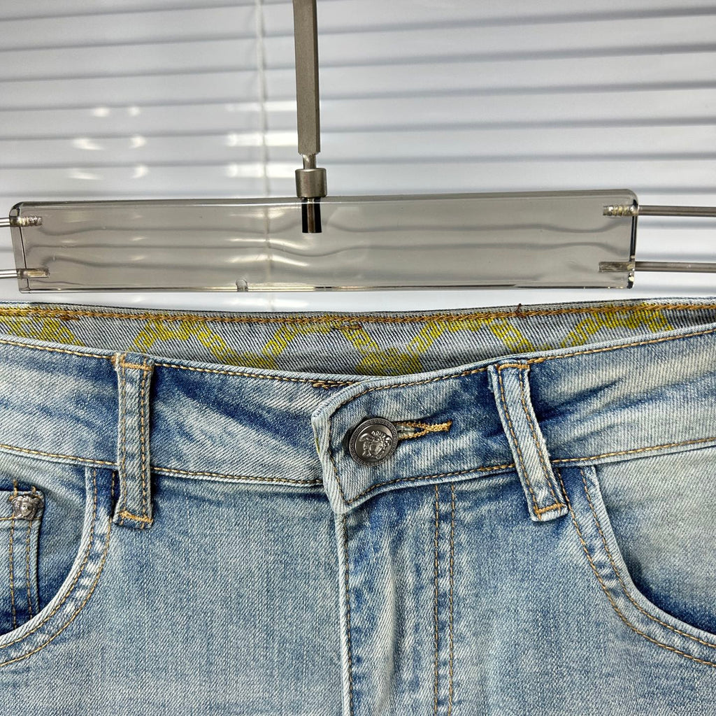 Light blue denim waistband with metal button, fly zipper, and belt loops