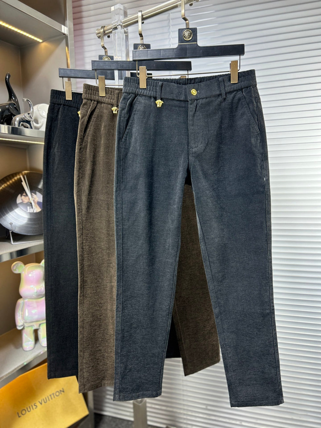 Versace trousers hanging together, dark brown and dark blue textured fabric, front pockets