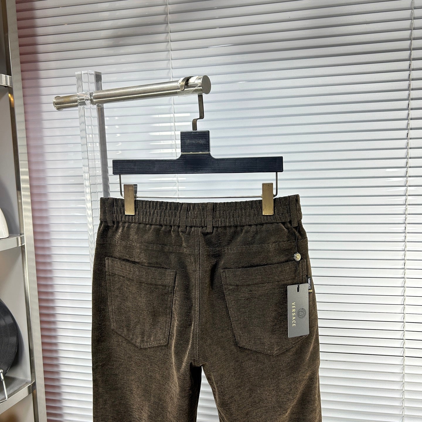 Versace trousers front view in dark brown textured fabric with side pockets and belt loops