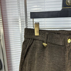 Versace trousers front close-up with side pocket, gold button detail, and belt loops