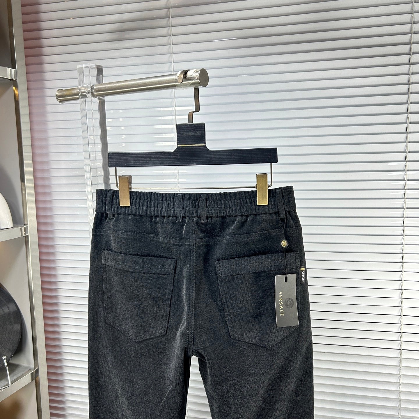 Dark denim trousers with two front pockets and buttoned fly
