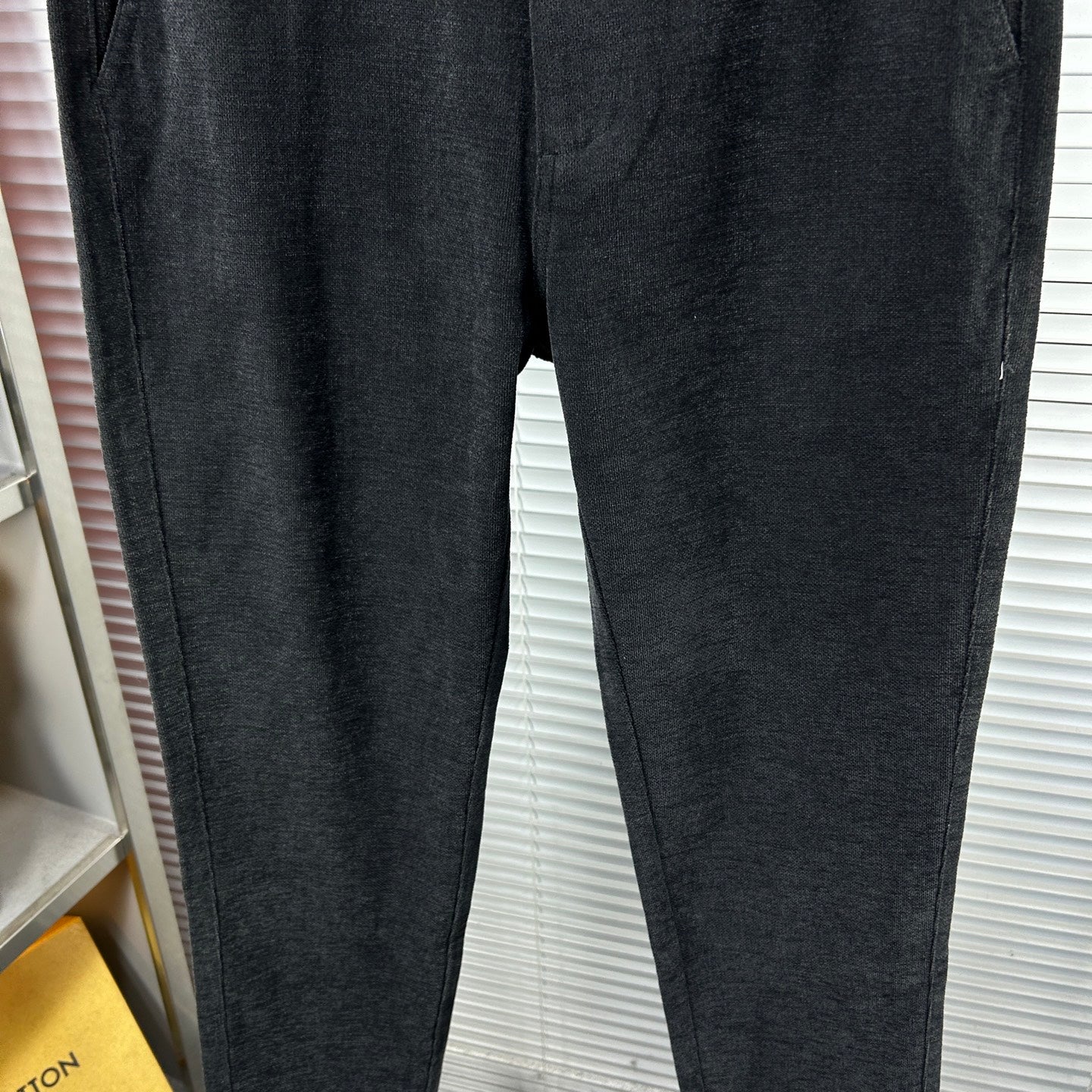 Dark trousers with straight legs and stitched side seam