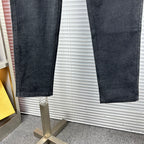 Dark denim pants showing straight leg openings and hem stitching
