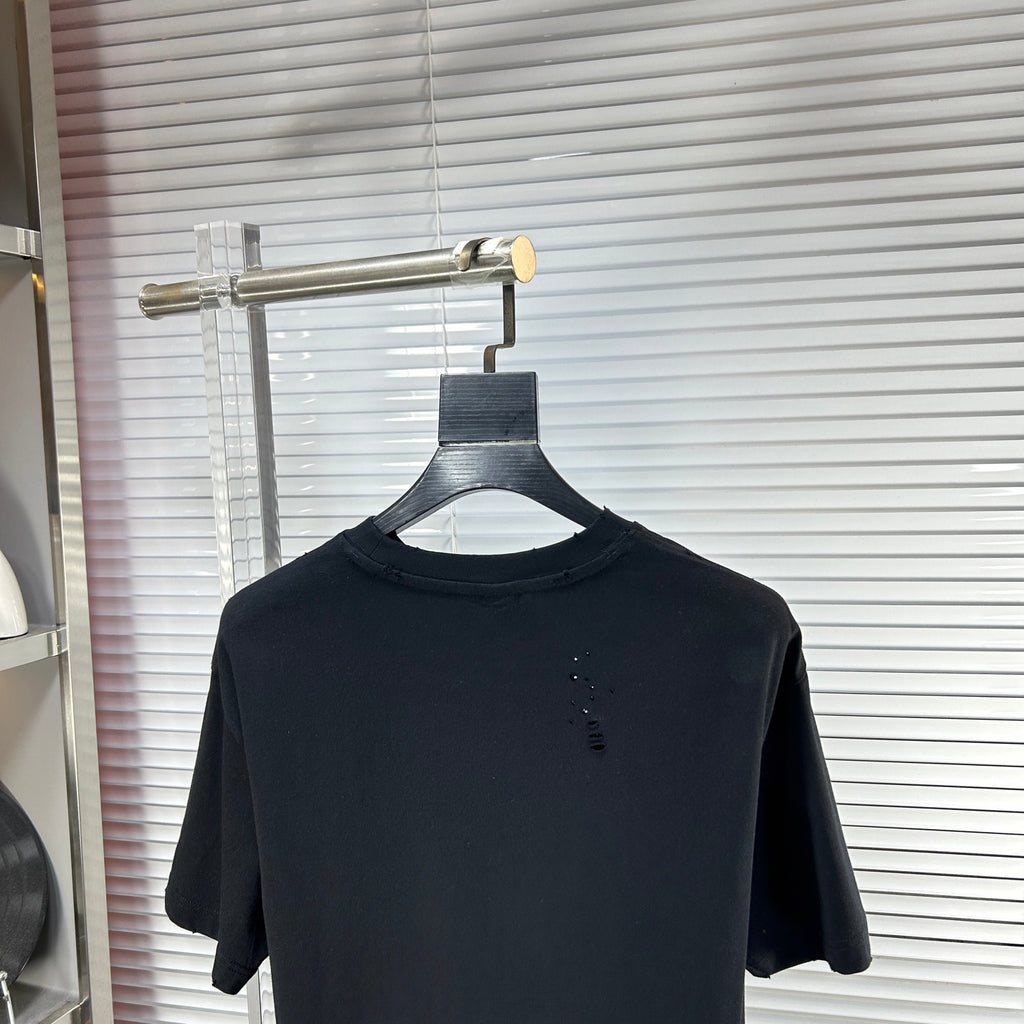 Black crew-neck T-shirt with short sleeves and small speckle detail on chest