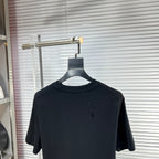Black crew-neck T-shirt with short sleeves and small speckle detail on chest