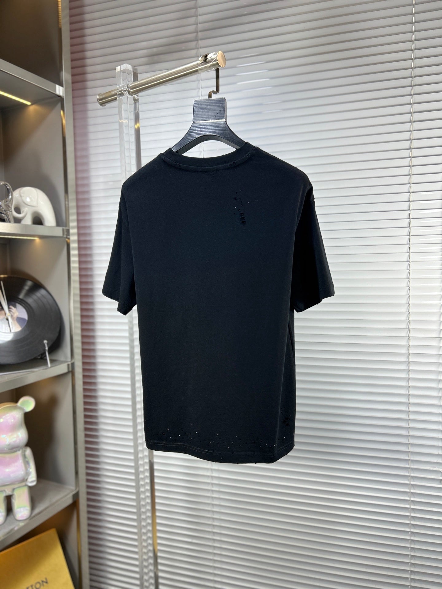 Black crew-neck T-shirt on hanger with short sleeves and subtle speckle detail