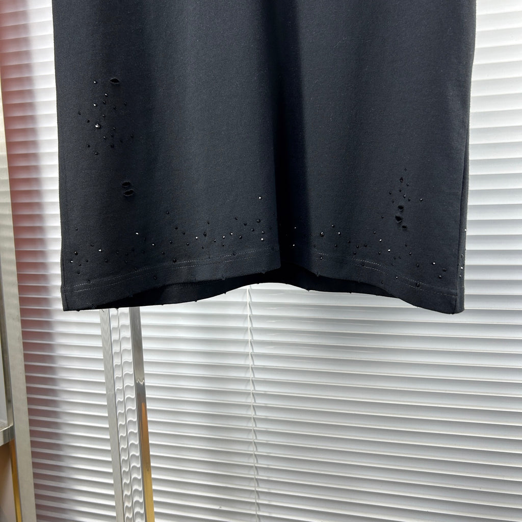 Black crew-neck T-shirt hem with scattered speckle and distressed dots