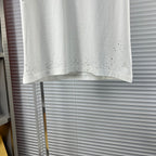Versace white T-shirt hem with perforated stud detailing across the bottom
