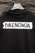 Balenciaga black T-shirt close-up with white BALENCIAGA logo across chest