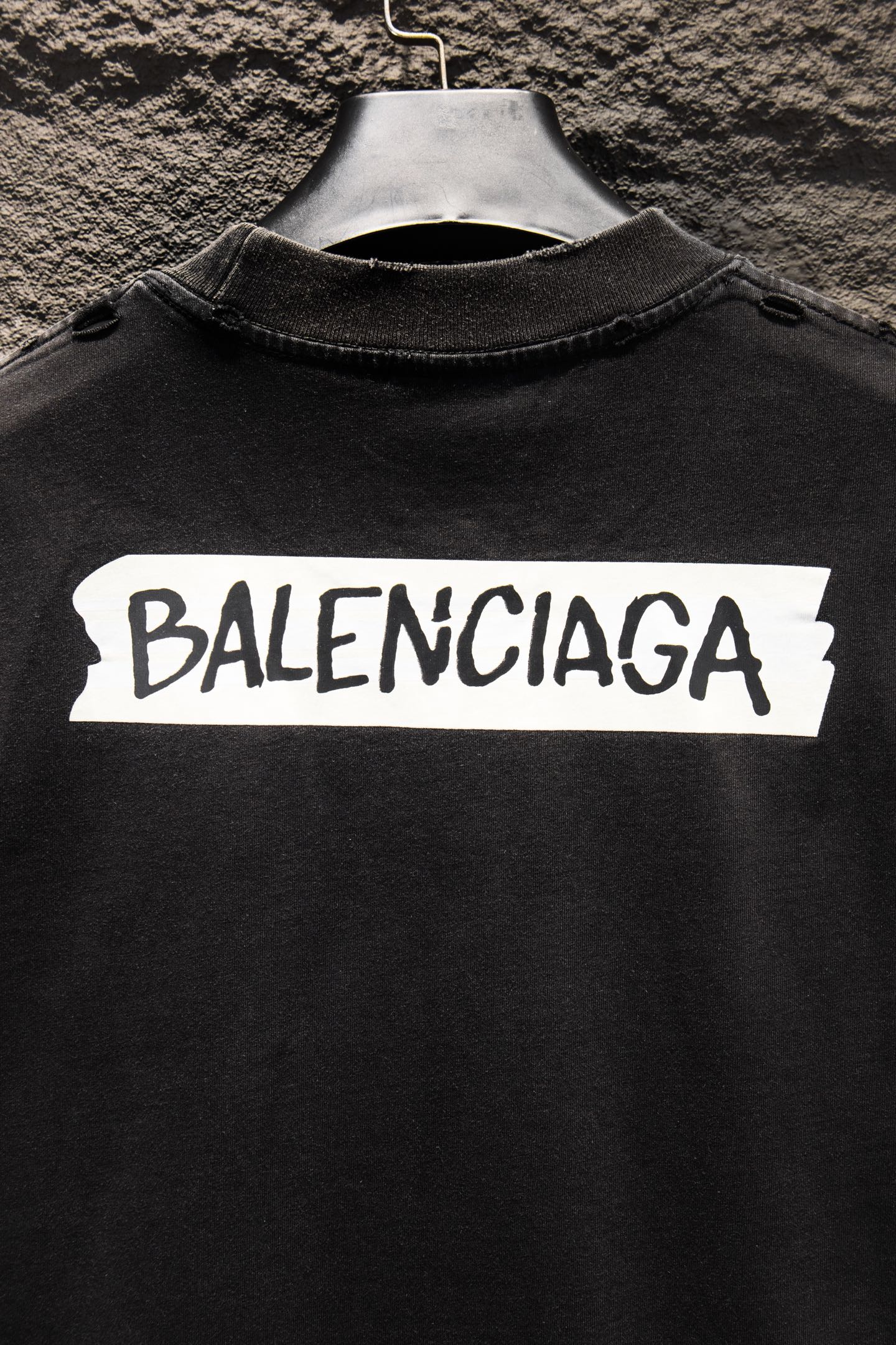 Balenciaga black T-shirt close-up with white BALENCIAGA logo across chest