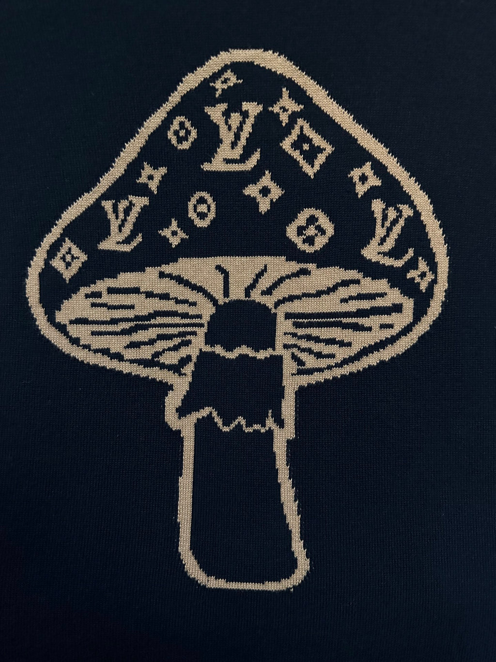 Embroidered gold and navy mushroom emblem on black T-shirt front