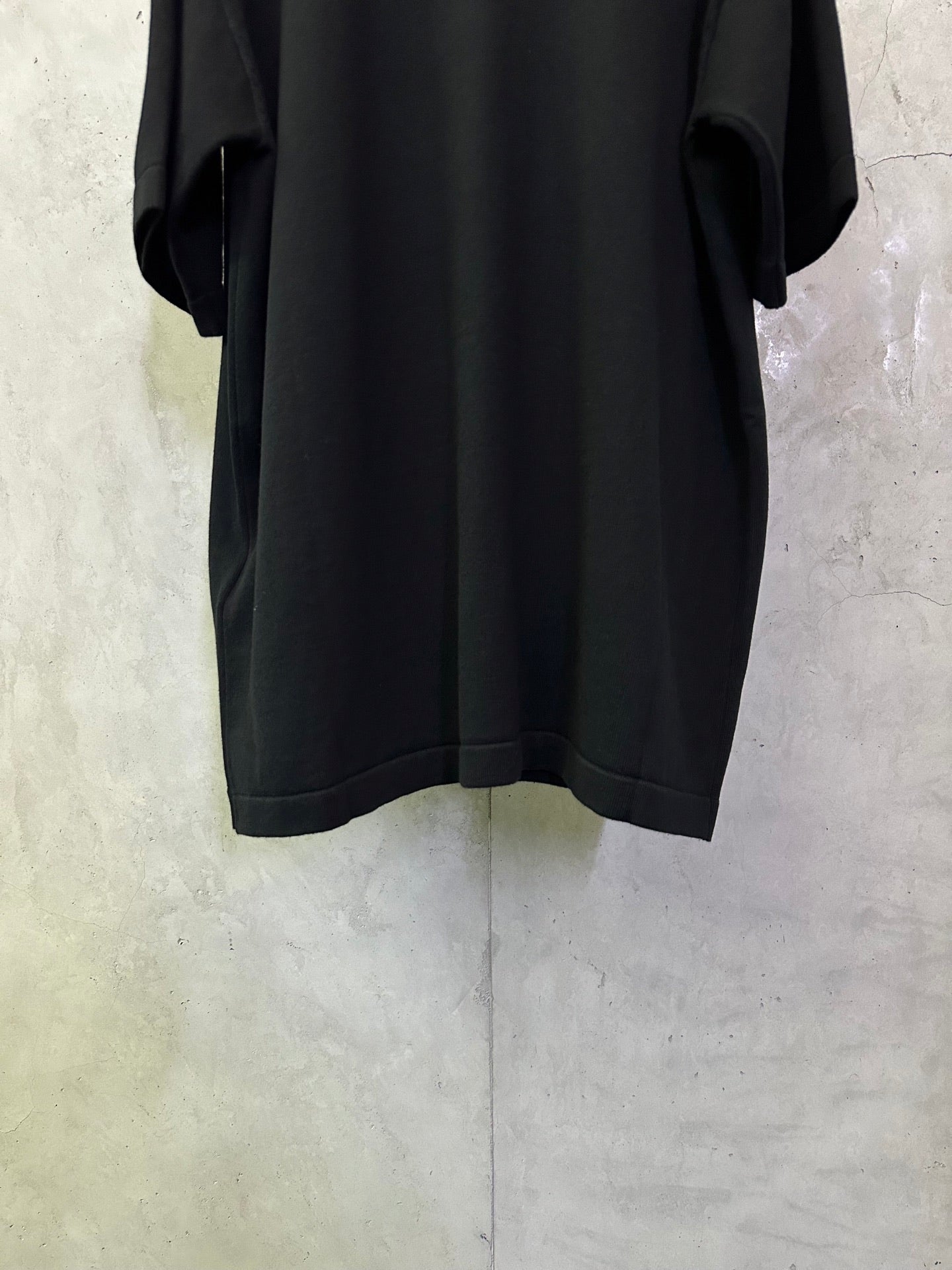 Black short-sleeve T-shirt, back view, loose fit with rounded hem