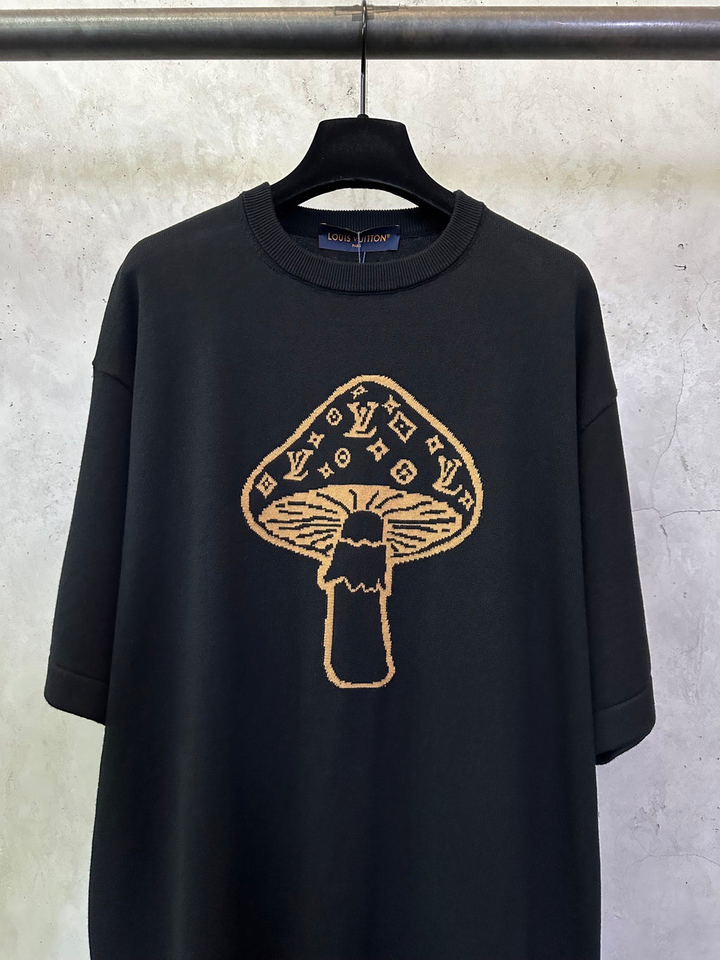 Black short-sleeve T-shirt with large gold mushroom emblem graphic