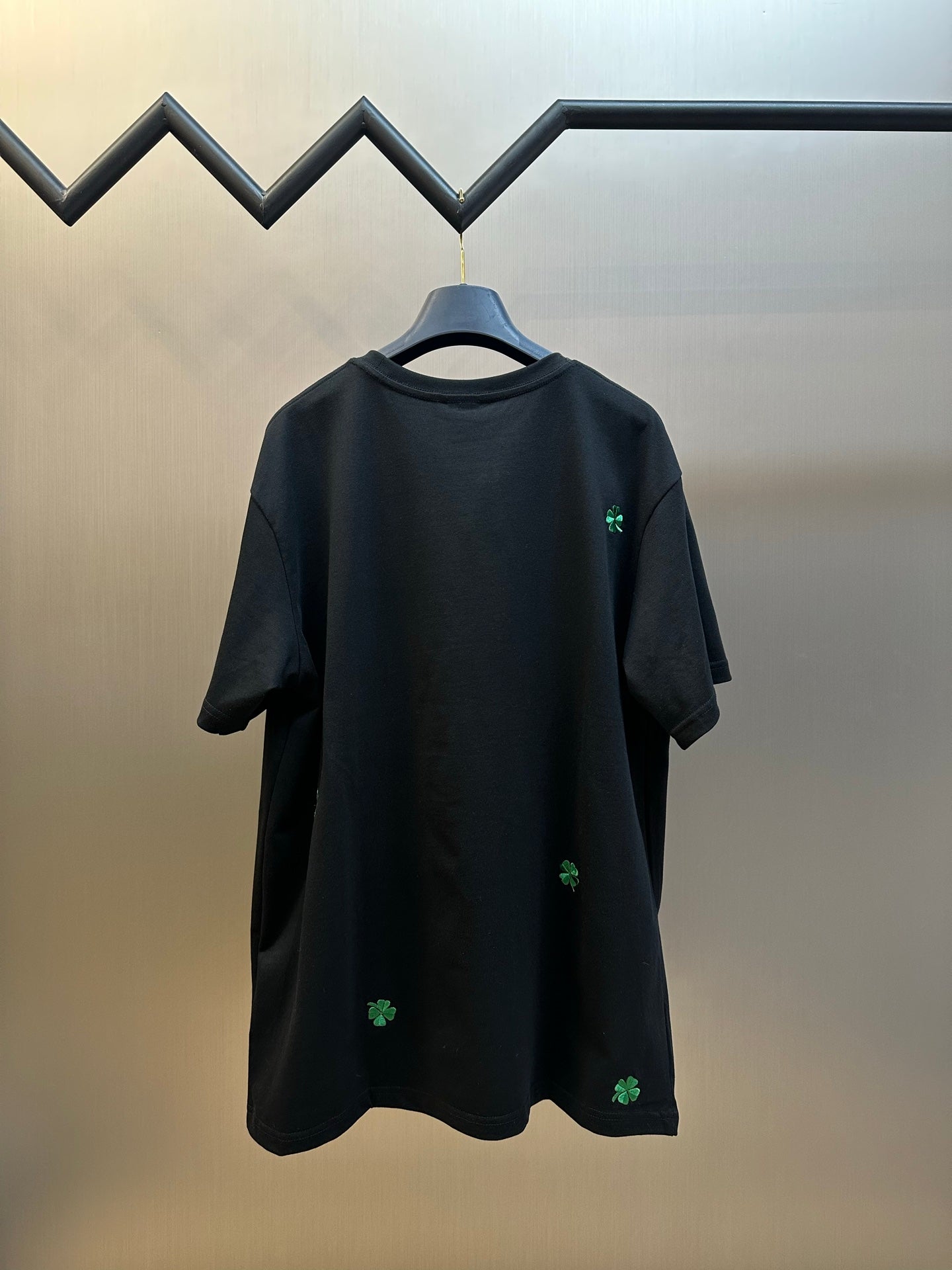 Black short-sleeve T-shirt with green clover embroidery on back